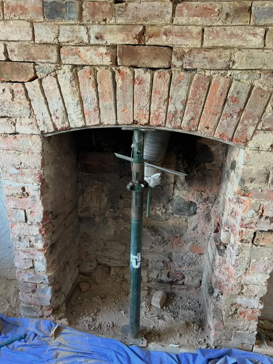Fireplace opening before restoration with temporary support